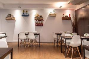 une salle à manger avec des tables et des chaises blanches dans l'établissement Petit Palace Arturo Soria Alcalá, à Madrid