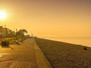 plaża z ławkami i słońce wschodzące nad wodą w obiekcie Endeavour House w mieście Cowes