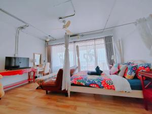 ein Schlafzimmer mit einem Bett, einem Sofa und einem Fenster in der Unterkunft มารินอส บีชเฮ้าส์ Marinos Beach house in Si Racha