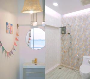 ein Bad mit einer Dusche, einem WC und einem Spiegel in der Unterkunft มารินอส บีชเฮ้าส์ Marinos Beach house in Si Racha