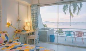 Schlafzimmer mit Balkon und Meerblick in der Unterkunft มารินอส บีชเฮ้าส์ Marinos Beach house in Si Racha