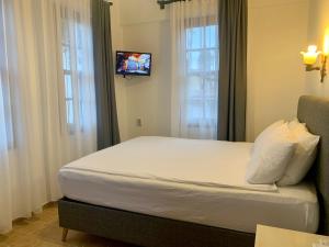 una camera con letto e TV a parete di Sabah Pansiyon a Antalya (Adalia)