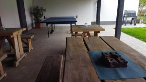 a room with wooden tables and a ping pong table at Holdudvar Apartman in Gyula