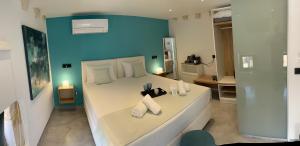 1 dormitorio con 1 cama blanca grande y pared azul en Antica Canea Luxury Rooms, en La Canea