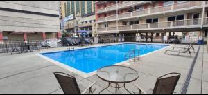 einen Pool mit einem Tisch und Stühlen in einem Gebäude in der Unterkunft Eldorado Atlantic City Beach Block in Atlantic City