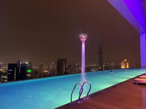 una piscina con vistas a la ciudad por la noche en The Platinum KLCC By Sky Pool, en Kuala Lumpur