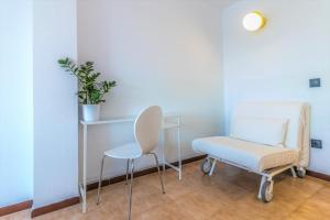 a hospital room with a chair and a table at Holidays Penthouse vues panoramiques sur le Port naval,un séjour élégant assuré " Wifi Pàrquing gratuït in Roses