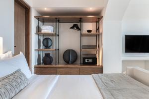 una camera con letto bianco e TV di Akra Suites & Spa a Imerovigli