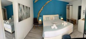 1 dormitorio con cama blanca y pared azul en Antica Canea Luxury Rooms, en La Canea