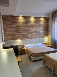 1 Schlafzimmer mit 2 Betten und einer Holzwand in der Unterkunft Hotel Europa Parking in Livorno