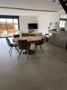 a living room with a wooden table and chairs at Charmant chalet, spacieux, proche du lac, vue sur la montagne in Gérardmer