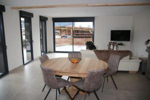 a living room with a wooden table and chairs at Charmant chalet, spacieux, proche du lac, vue sur la montagne in Gérardmer