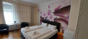 1 dormitorio con 1 cama con una pintura floral en la pared en Hotel Restaurant Hellas, en Gelting