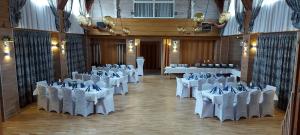 un salón de banquetes con mesas blancas y sillas blancas en Hotel Restaurant Hellas, en Gelting