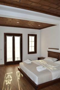 1 dormitorio con 2 camas y 2 ventanas en Pupa Winery Serene Stay, en Berat