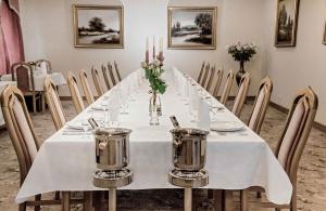 a long table with a white table cloth and candles at Adler in Swarzędz