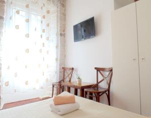 una camera con tavolo, sedie e TV a parete di Rooms and Apartments Djanovic a Spalato (Split)