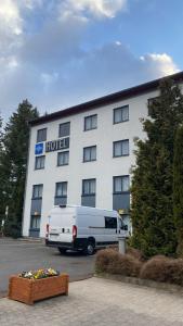 ein weißer Van vor einem Hotel geparkt in der Unterkunft Olympia Hotel Suhl in Suhl