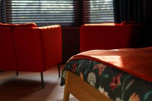 a room with two red chairs and a bed at à la pointe de l'ile in Namur