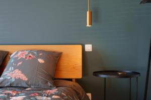 a bedroom with a bed with a wooden headboard and a table at à la pointe de l'ile in Namur