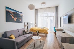 uma sala de estar com um sofá e uma cama em Apartmány Tatry em Starý Smokovec