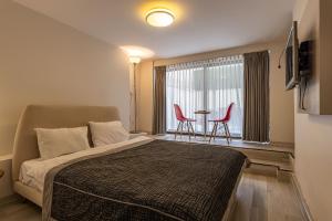 a bedroom with a bed and a window with red chairs at Calanthe Residence in Istanbul