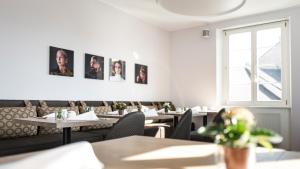 BASE II - Das Bed & Breakfast bei Basel (Lörrach) في لاروش: مطعم بطاولات وكراسي ونافذة