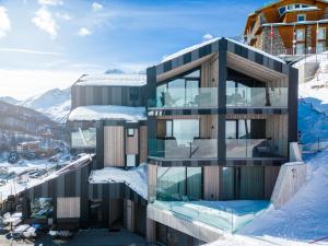 um edifício no topo de uma montanha coberta de neve em Bergman Mountain Hotel em Breuil-Cervinia