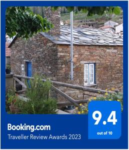 a stone house with a sign that says travel review awards at Casa do Loureiro in Arganil