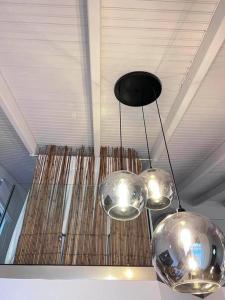 three lights hanging from the ceiling in a room at Orsalia villa wellness in Poros