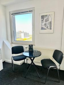 um quarto com uma mesa e duas cadeiras e uma janela em Ferienwohnung Flaming House Bitterfeld em Bitterfeld