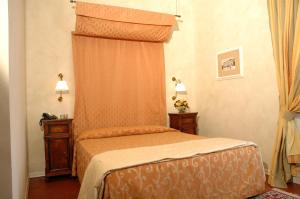 a bedroom with a bed with an orange canopy at Hotel Clitunno in Spoleto