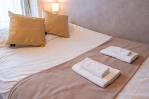 a bed with two pillows and two towels on it at A-Style Matsu 602 in Osaka