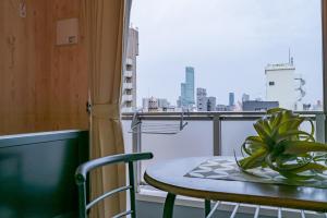 a table with a plant on a balcony with a view at A-Style Matsu 602 in Osaka