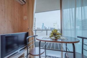 a room with a table and a tv and a window at A-Style Matsu 602 in Osaka