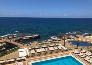 - une vue aérienne sur un complexe avec une piscine et l'océan dans l'établissement Castel Mare Beach Hotel & Resort, à Byblos