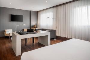 uma sala de estar com uma secretária branca e um sofá em AC Hotel Porto by Marriott no Porto