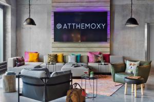 a living room with a couch and chairs at Moxy Munich Ostbahnhof in Munich