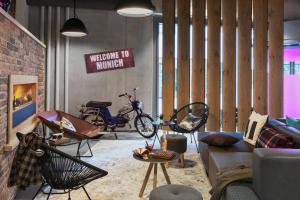 a living room with a couch and motor scooters at Moxy Munich Ostbahnhof in Munich