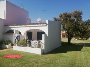 uma casa com um quintal com um cobertor vermelho na relva em Vilamoura Alecrim em Vilamoura