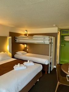 a hotel room with two bunk beds and a table at Campanile Troyes Sud - Buchères in Troyes