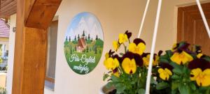 un cartel en la pared de una casa con flores en Hős-Ceglédi Vendégház Miskolc -Önálló otthon, mely csak az Önöké, en Miskolc