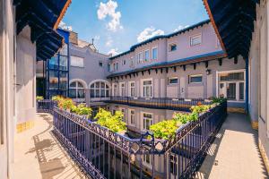 ein Gebäude mit Topfpflanzen auf einem Balkon in der Unterkunft Baross City Hotel - Budapest in Budapest