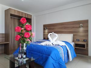 PRIVATE ROOMS - DOWNTOWN AREQUIPA - Adults Only في أريكيبا: غرفة نوم فيها سرير مع ورود وبجعة عليها