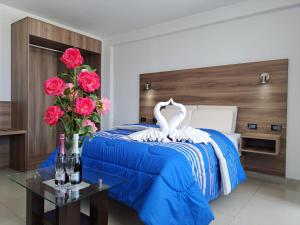 PRIVATE ROOMS - DOWNTOWN AREQUIPA - Adults Only في أريكيبا: غرفة نوم بسرير بجعة وورد