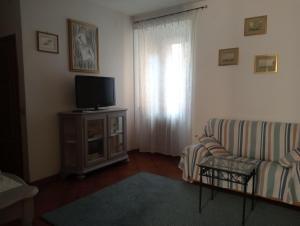 ein Wohnzimmer mit einem Sofa und einem TV in der Unterkunft Casa Azzurra in Orbetello