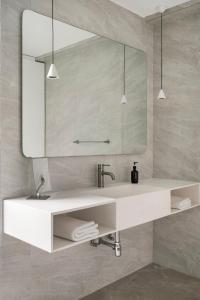 a bathroom with a white sink and a mirror at Bungalow 157 in New Delhi