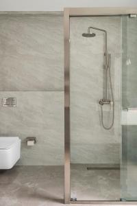 a shower with a glass door in a bathroom at Bungalow 157 in New Delhi