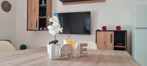 una camera con tavolo, TV e vaso con fiori di LuengiHouse - Espectacular apartamento con piscina a Lloret de Mar