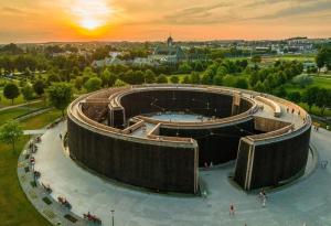 um edifício com piscina no meio de um parque em Apartamenty przy Tężni em Busko-Zdrój